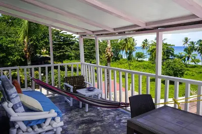 a porch with a hammock and a view of the ocean at B&B Aparthotel La Isleta in Las Galeras