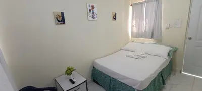 a small bed in a white room with a window at HEA Stays in San Felipe de Puerto Plata