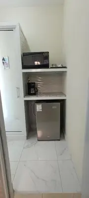 a kitchen with a counter with a microwave on a shelf at HEA Stays in San Felipe de Puerto Plata