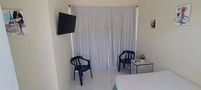 a bedroom with two chairs and a bed and a window at HEA Stays in San Felipe de Puerto Plata