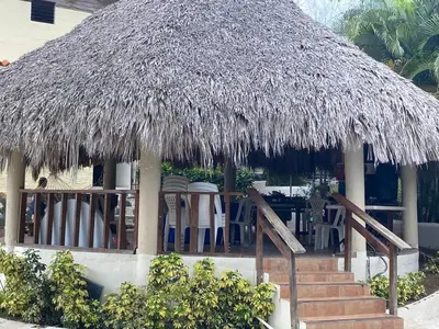 a straw hut with stairs and chairs and tables at VILLA LOMAS LINDAS in La Montosa