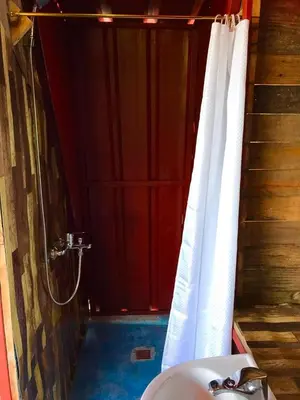 a bathroom with a sink and a shower with a shower curtain at Tinyhouse samaná