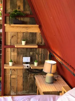 a room with wooden walls and a table with a lamp at Tinyhouse samaná