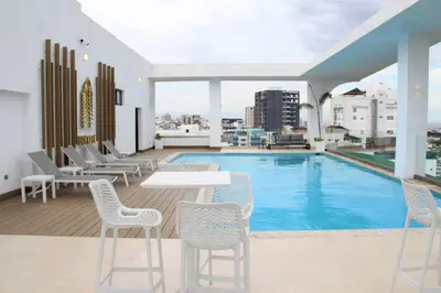 a pool with chairs and a table on a building at Brickell Hotel apto g 08 Santo Domingo Bella Vista in Santo Domingo