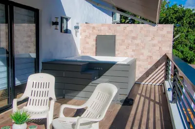 two white chairs and a hot tub on a deck at Villa vista al rio in Jarabacoa