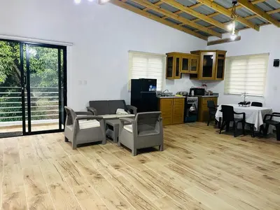 a living room with a table and chairs and a kitchen at Villa vista al rio in Jarabacoa