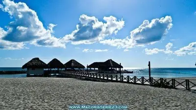 a pier with huts on a beach with the ocean at Elegant Blue Sky View Lux at Juan Dolio Las Velas in Juan Pedro
