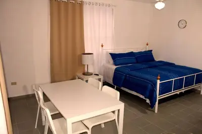 a bedroom with a bed and a table and a table and chairs at Dominican Suite 11, Amazing Apt/Studio (DS11) in San Felipe de Puerto Plata