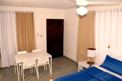 a bedroom with a bed and a white table and chairs at Dominican Suite 11, Amazing Apt/Studio (DS11) in San Felipe de Puerto Plata