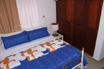 a bedroom with a bed with a blue and white comforter at Dominican Suite 23, Incredible 1 Bed Apt (DS23) in San Felipe de Puerto Plata