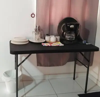 a black table with plates and a coffee maker on it at Dominican Suite 1, Incredible Suite/Studio (DS1) in San Felipe de Puerto Plata