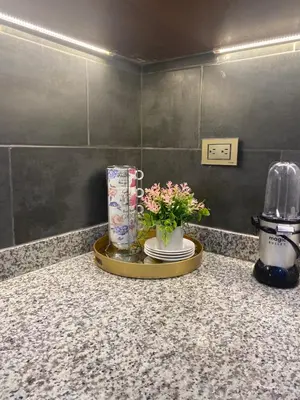a counter with a tray with a vase of flowers on it at VIP Home in Santiago de los Caballeros