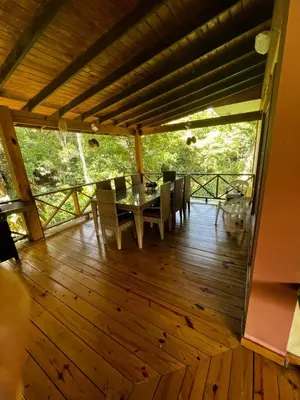 a dining room with a table and chairs on a deck at Hacienda Claro de Luna 3 Bedrooms in Jarabacoa