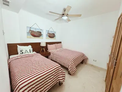 a bedroom with two beds and a ceiling fan at Fortunity Club- Playa Dorada, Pto Plata in Sampiño