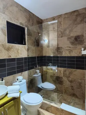 a bathroom with a toilet and a glass shower at Hotel La Casona MC in La Romana