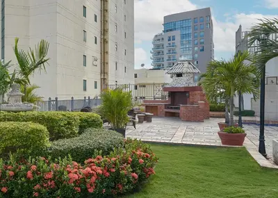 a courtyard with a garden with bushes and flowers at VIP Exclusive One Bedroom Apartment in Santo Domingo