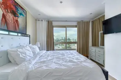 a bedroom with a white bed and a window at VIP Exclusive One Bedroom Apartment in Santo Domingo
