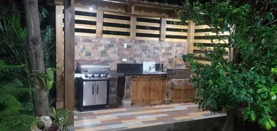 an outdoor kitchen with a grill and a stove at Villa Rosalía Jarabacoa con Piscina Climatizada in Jarabacoa
