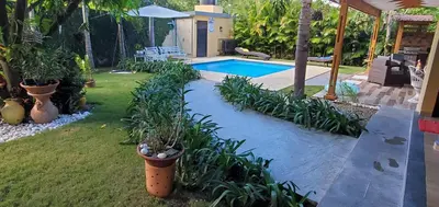 a backyard with a swimming pool and some plants at Villa Rosalía Jarabacoa con Piscina Climatizada in Jarabacoa