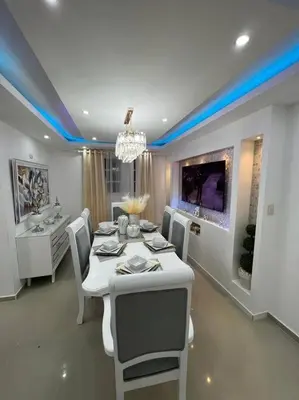 a dining room with a white table and chairs at Luxury apartment with Pool in Santiago de los Caballeros