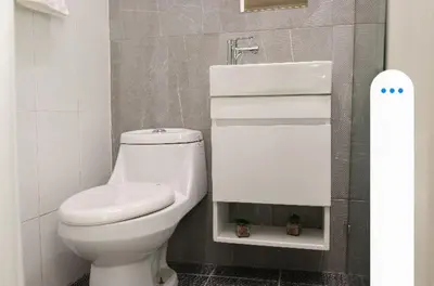 a bathroom with a white toilet and a sink at Residencial Frank I in Santo Domingo