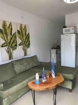 a living room with a green couch and a table at Juan Dolio apart1 hab in Juan Pedro