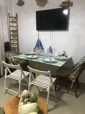 a dining room table with chairs and a tv at Juan Dolio apart1 hab in Juan Pedro