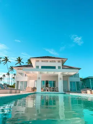 a villa with a swimming pool in front of a house at Peninsula Esmeralda Luxury Hotel & Villas in San Felipe de Puerto Plata