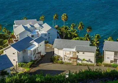a row of white houses next to the ocean at Lovely house with private beach in Santa Bárbara de Samaná