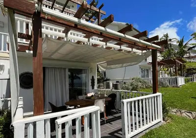 a white pergola on the back of a house at Lovely house with private beach in Santa Bárbara de Samaná