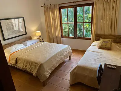 a bedroom with two beds and a window at CABARETE BEACH HOUSES the NANNY ESTATES in Cabarete