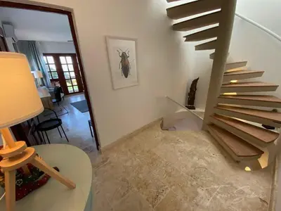 a spiral staircase in a living room with a table at CABARETE BEACH HOUSES the NANNY ESTATES in Cabarete