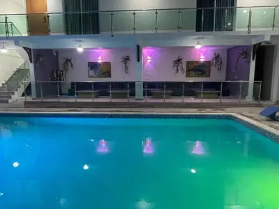a swimming pool with blue water and purple lights at El Paso Hotel in Arroyo de Agua