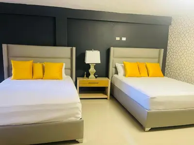 two beds with yellow pillows in a bedroom at El Paso Hotel in Arroyo de Agua