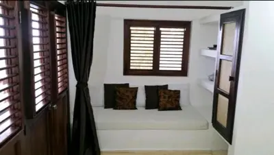 a room with two windows and a bench with pillows at Bungalow de Ballenas in Punta Balandra
