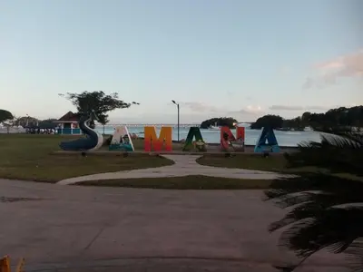 a park with colorful signs next to a body of water at Bungalow de Ballenas in Punta Balandra