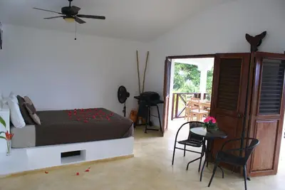 a bedroom with a bed and a table and chairs at Bungalow de Ballenas in Punta Balandra