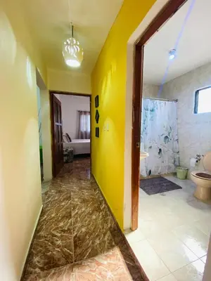 a large bathroom with a yellow wall and a toilet at Villa Marcia in Boca Chica