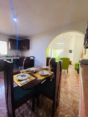 a dining room with a table with plates and wine glasses at Villa Marcia in Boca Chica