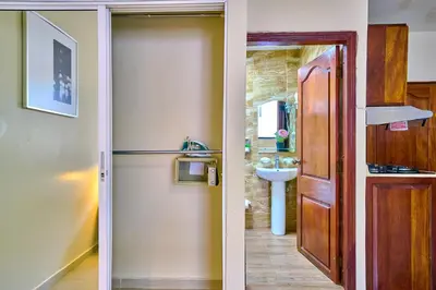 two images of a bathroom with a door and a sink at Hotel Libertad at historic main street in Santo Domingo