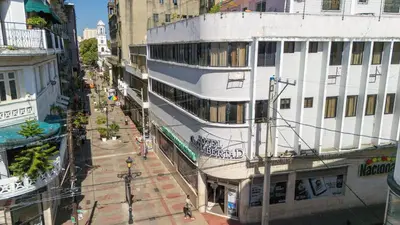 a large white building on a street in a city at Hotel Libertad at historic main street in Santo Domingo