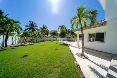 a yard with palm trees next to a house at Casa Blanca - White House in Cabarete