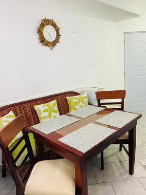a wooden table with chairs and a mirror on the wall at Casa Blanca - White House in Cabarete