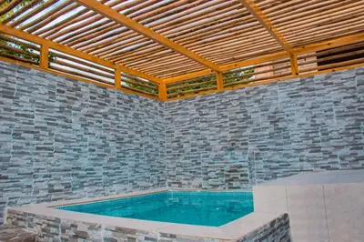 a large swimming pool in a brick wall at D' Yoko Village's in Pedernales