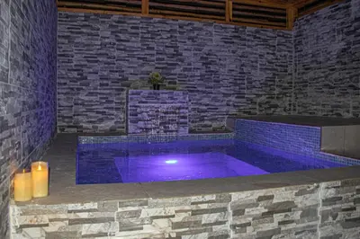 a swimming pool with purple lighting in a brick wall at D' Yoko Village's in Pedernales