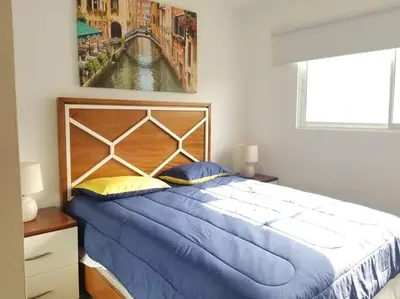 a bedroom with a large bed with a painting on the wall at Las vacaciones que soñaste en un lugar seguro! in Santiago de los Caballeros
