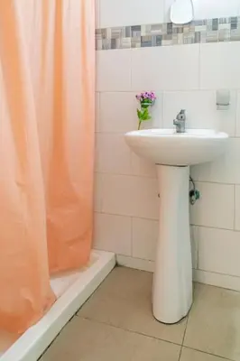 a bathroom with an orange shower curtain and a sink at Cerca del Mar, Obelisco Macho y Zona Colonial in Santo Domingo