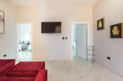 a living room with a red couch and a flat screen tv at The Green Palms 5 Bedroom villa with pool / garden in San Felipe de Puerto Plata