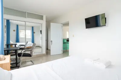 a bedroom with a bed and a table with a chair at Mi refugio cerca del aeropuerto in Santo Domingo
