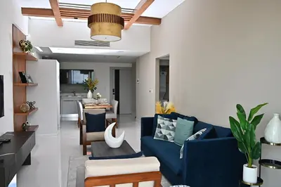 a living room with a blue couch and a kitchen at Piantini’s Skylight in Santo Domingo